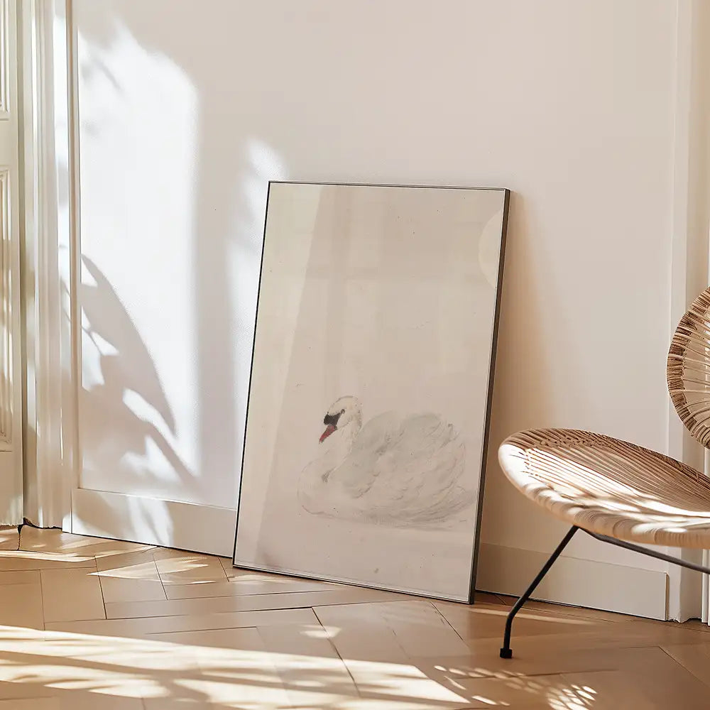 Framed painting of a white swan resting against a light wall, leaning on the floor with a chair nearby.