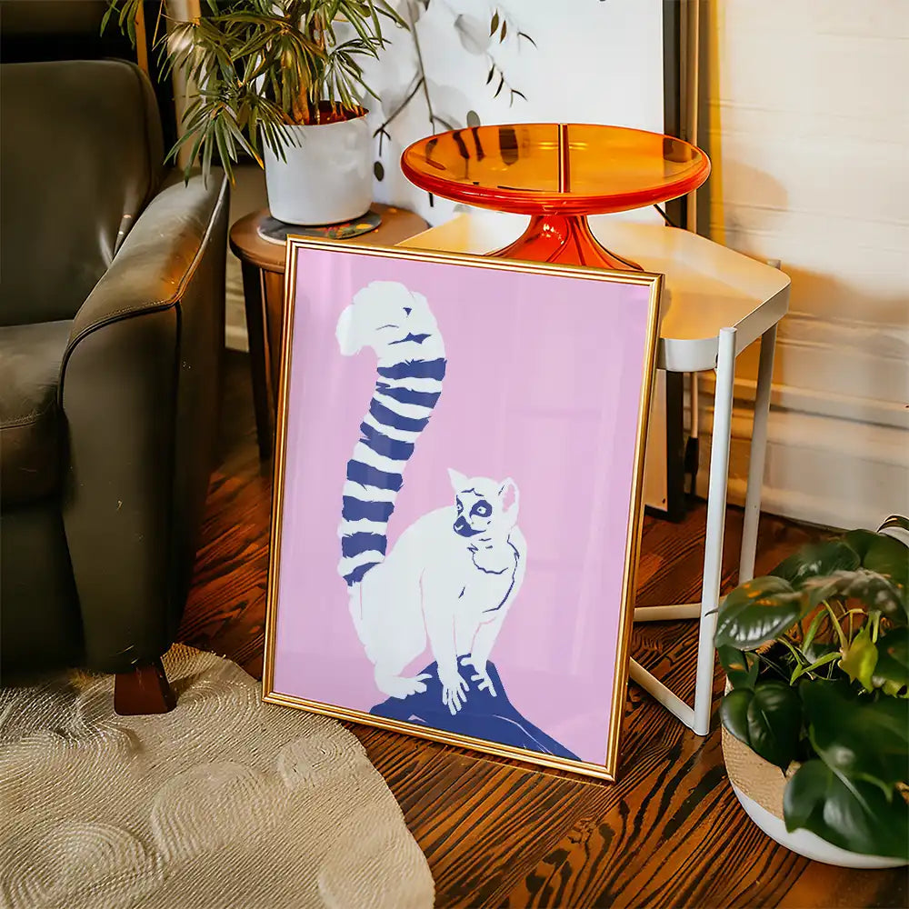 Modern poster of a stylized cat with a striped tail on a pink background, framed, showcasing contemporary art aesthetics in a cozy living room setting.