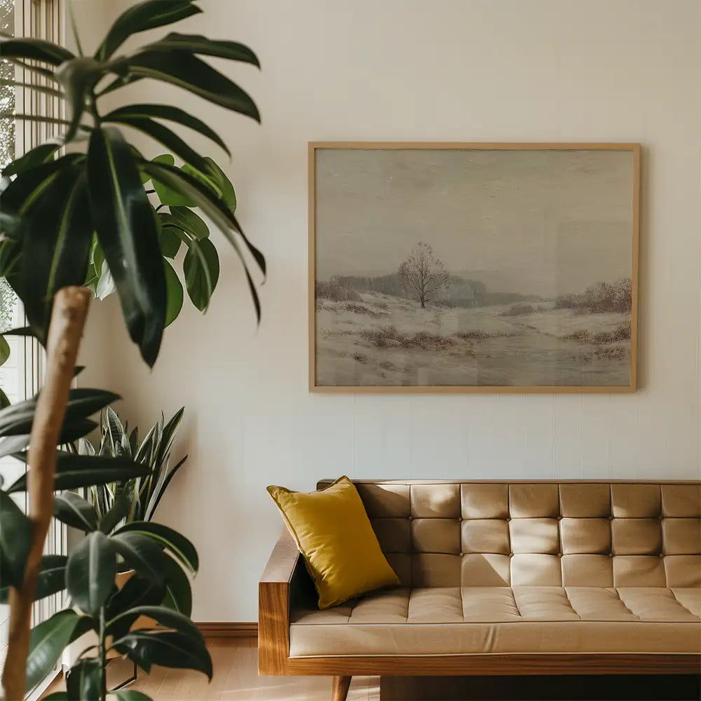 A framed landscape painting hanging on a white wall, with a cozy brown couch and a yellow pillow in the foreground, and greenery from indoor plants.