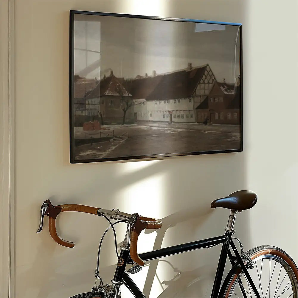 Painting of a serene landscape with traditional buildings, displayed above a black bicycle in a well-lit room.