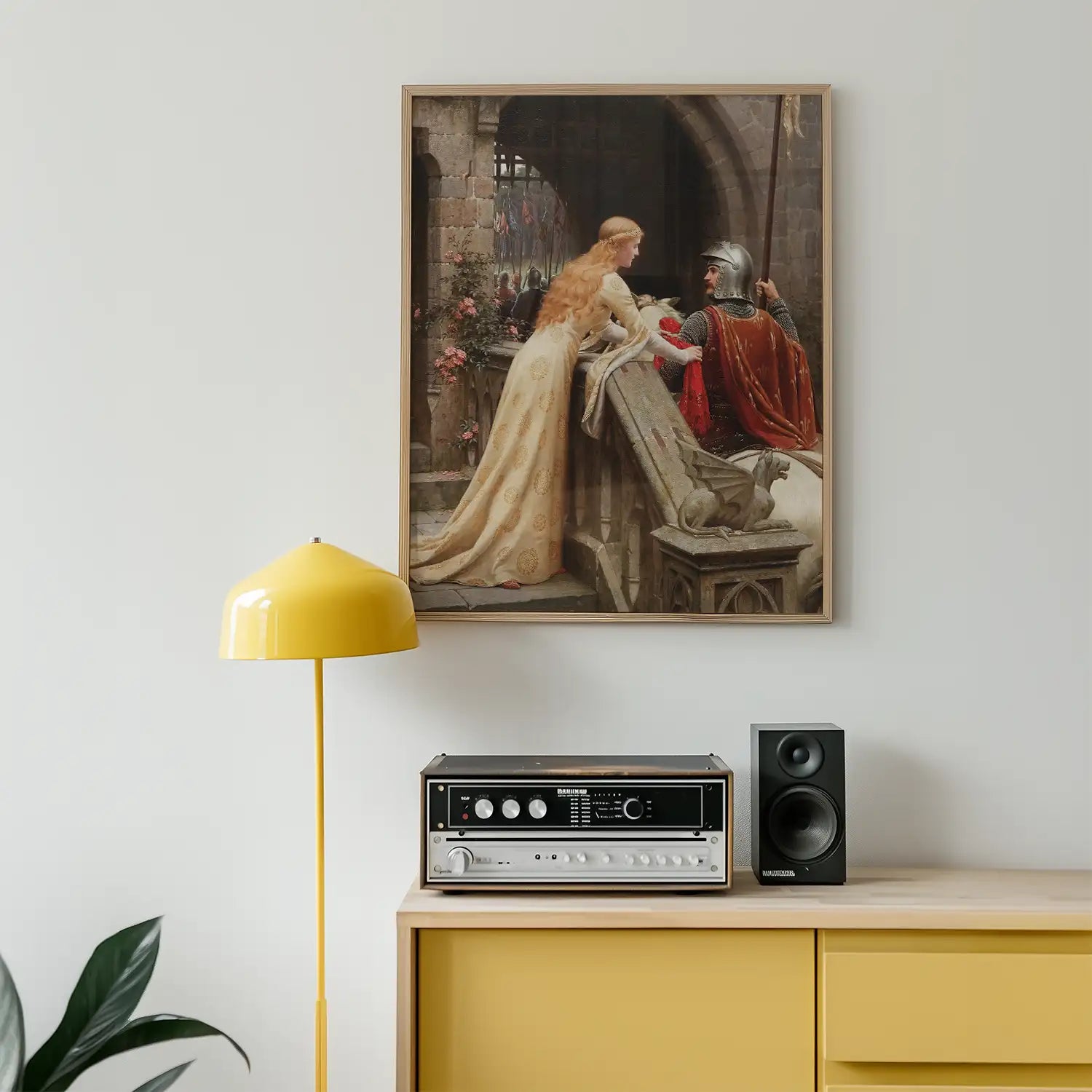 Painting of a medieval scene featuring a woman in a flowing gown and a knight, framed and displayed on a wall above a yellow lamp and a stereo speaker on a wooden cabinet.