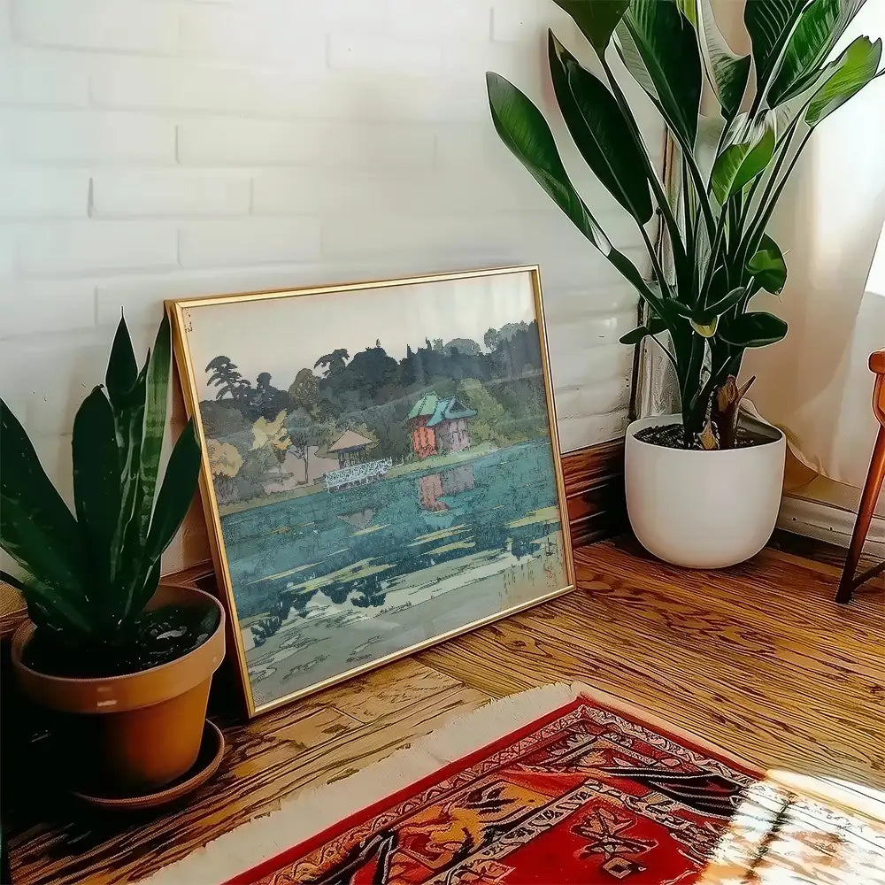 Framed painting depicting a serene landscape with a water feature, surrounded by indoor plants and cozy home decor elements.