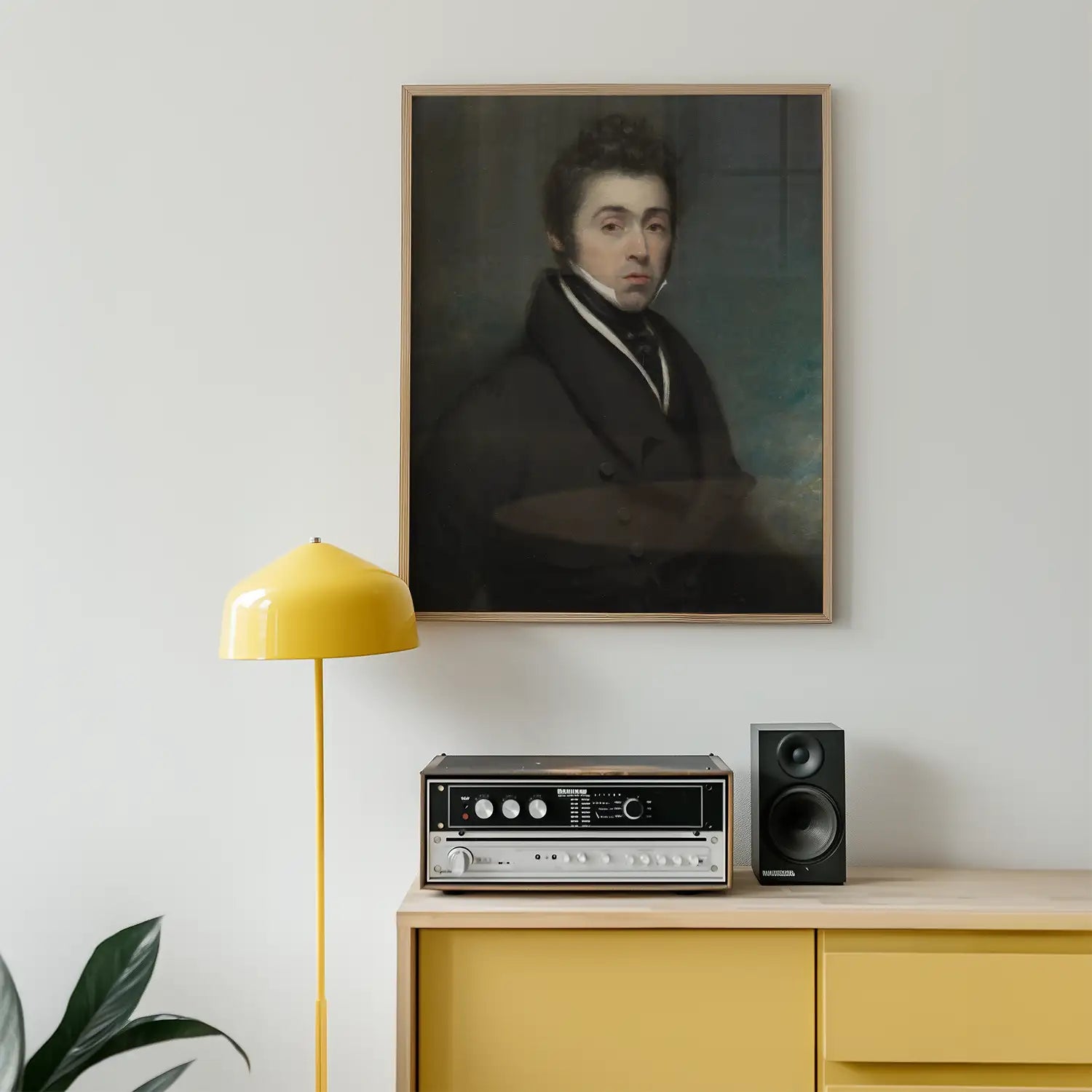 Framed portrait painting of a man, displayed on a wall above a yellow lamp and a vintage stereo on a wooden cabinet