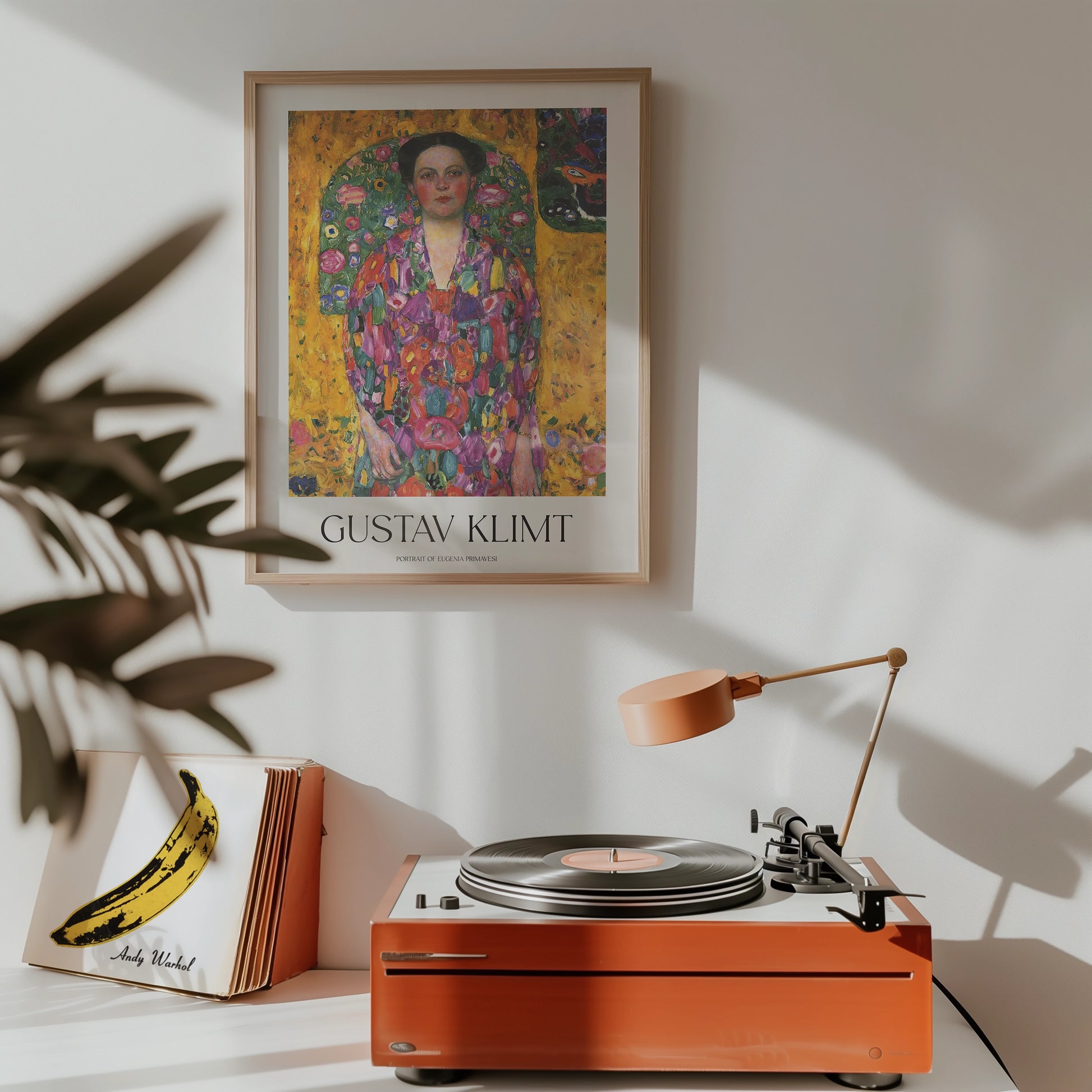 A stylish interior featuring a framed Gustav Klimt painting titled "Portrait of Eugenia Primavesi" above a vintage turntable and decorative items.