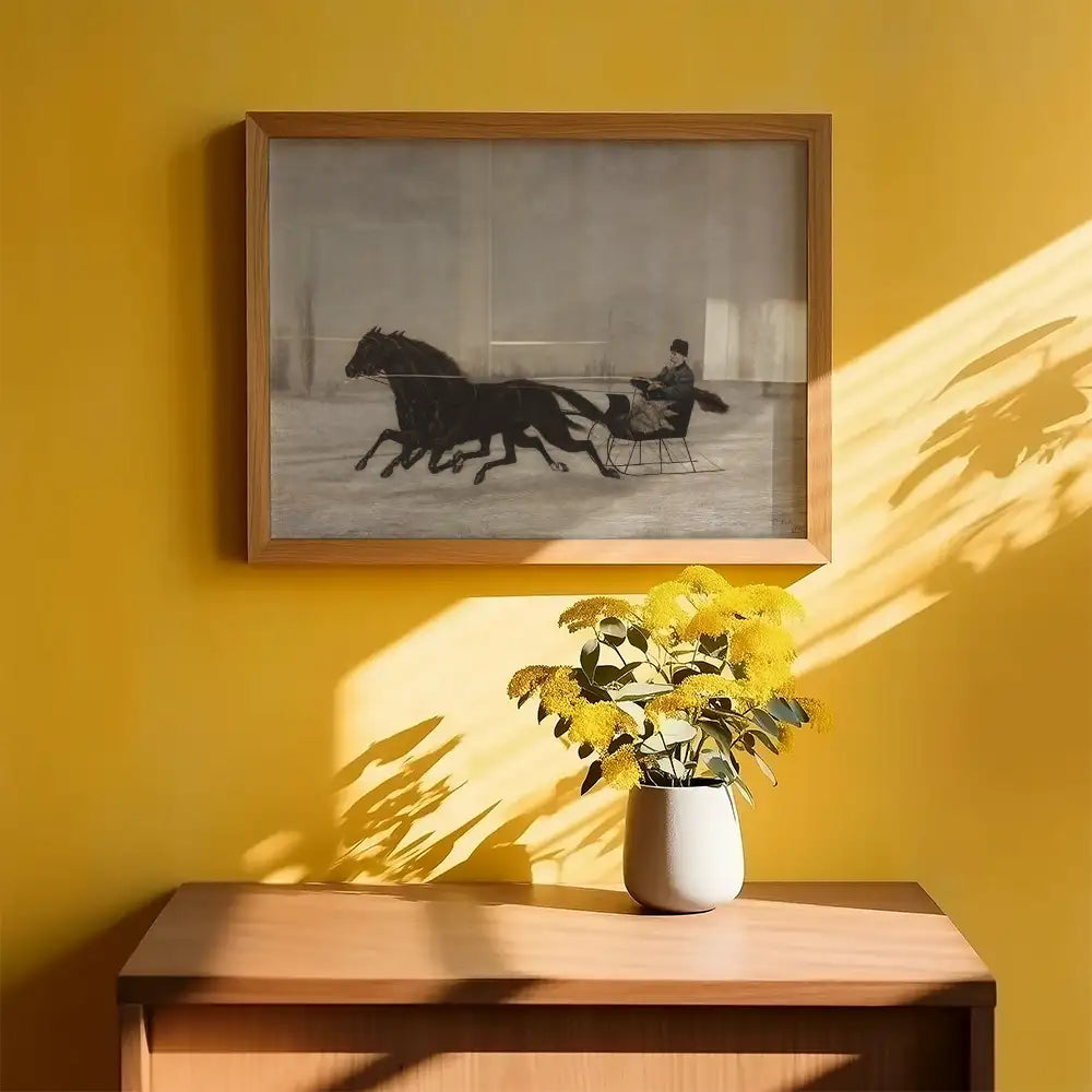 Framed painting of a horse-drawn sleigh in motion, displayed on a vibrant yellow wall, with a vase of yellow flowers in the foreground.