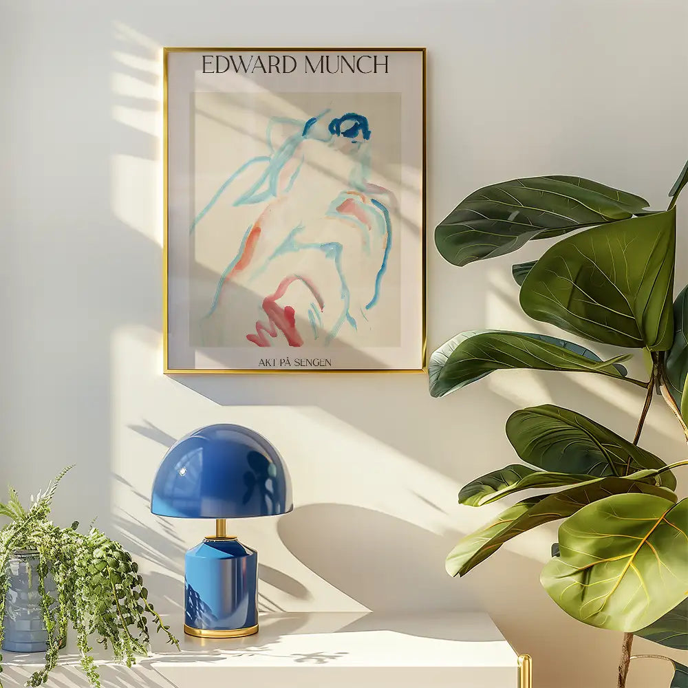 Painting of a figure by Edward Munch in a gold frame, displayed on a wall next to a blue lamp and a leafy plant.