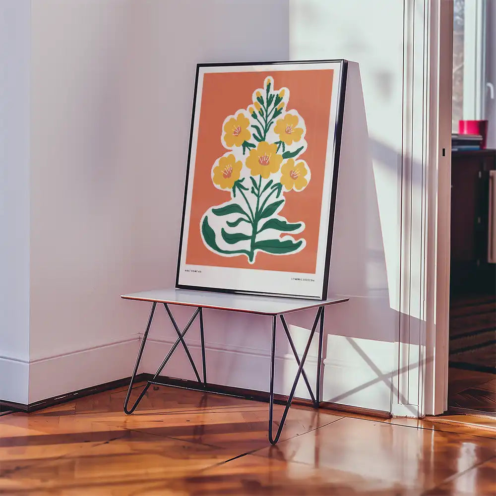 Modern floral poster print featuring vibrant yellow flowers against a coral background, elegantly displayed on a minimalist table in a bright interior setting.