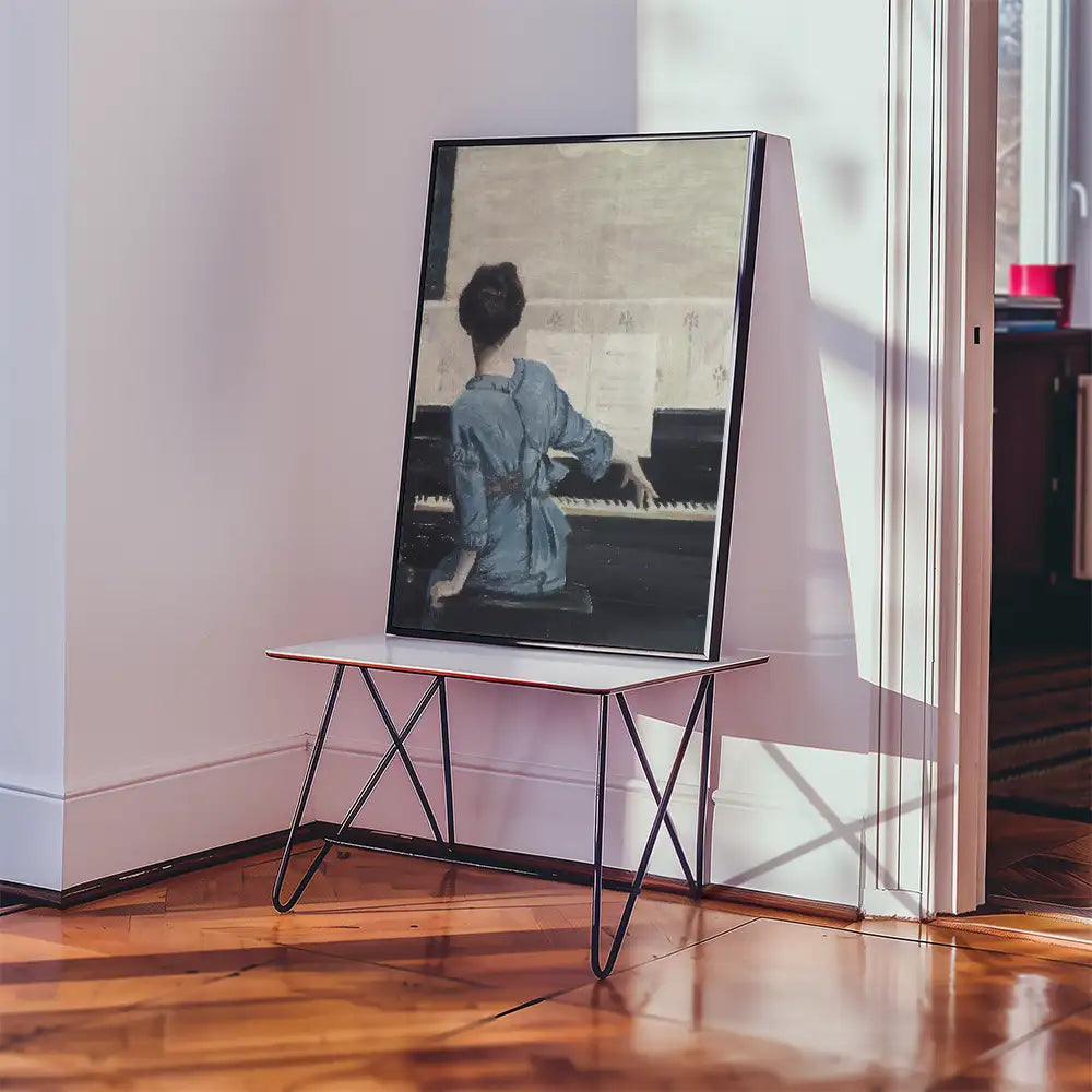 Painting of a woman in a blue dress playing the piano, displayed on a modern easel in a well-lit room.