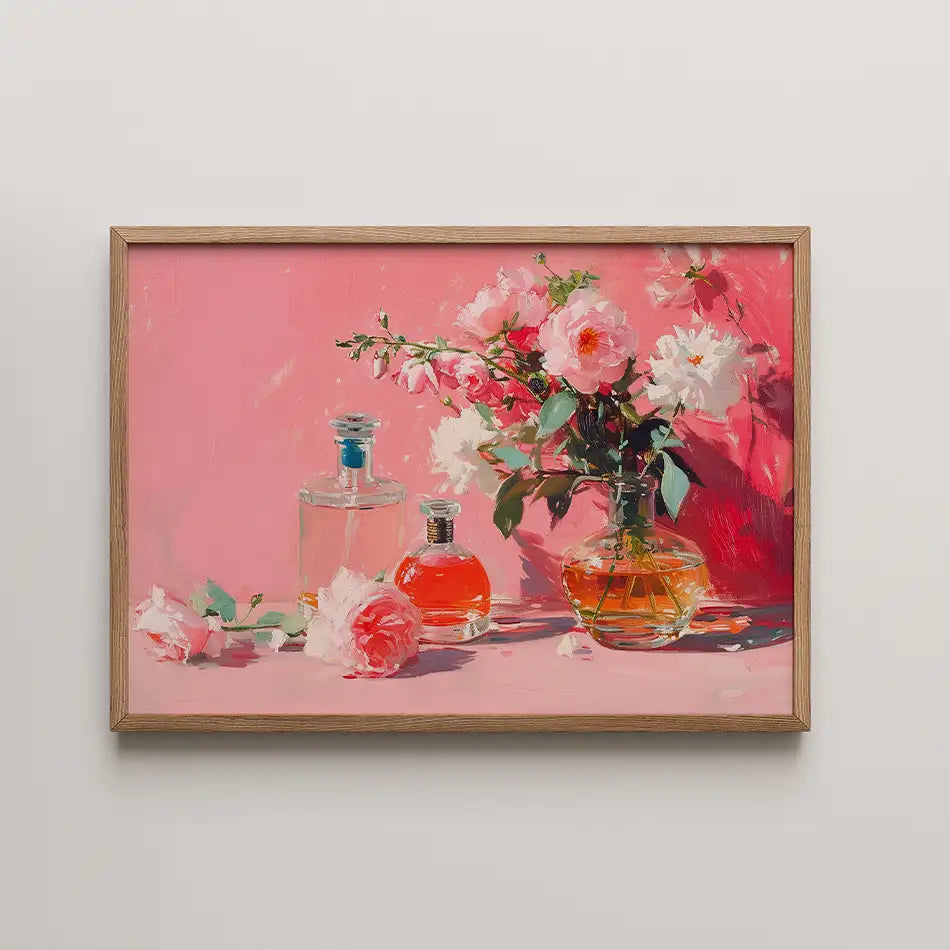 Painting of perfume bottles and pink flowers against a pink background in a wooden frame.