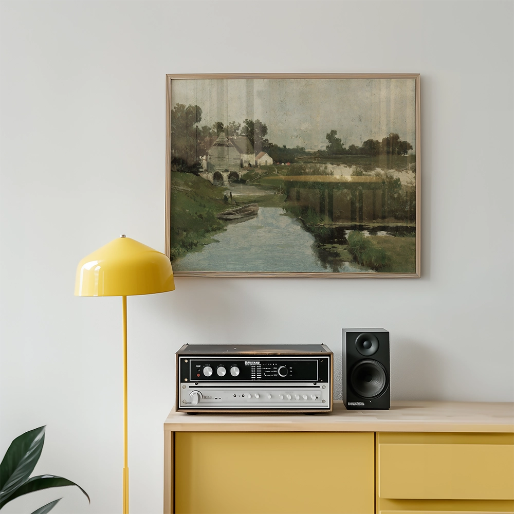 Painting of a serene riverside landscape featuring a small boat, framed on a wall above a modern yellow lamp and a vintage audio system.