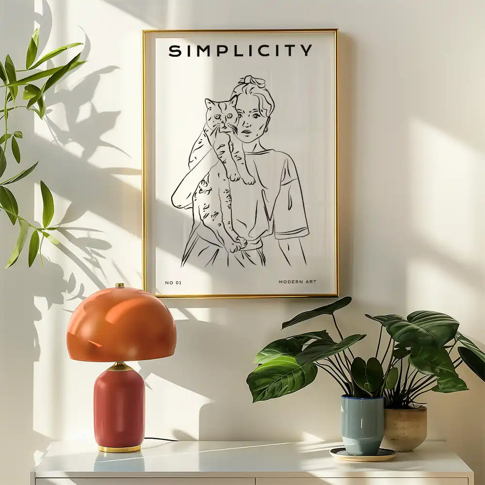 Modern line art poster titled "Simplicity," featuring a woman holding a cat, framed in gold, enhancing contemporary home decor.