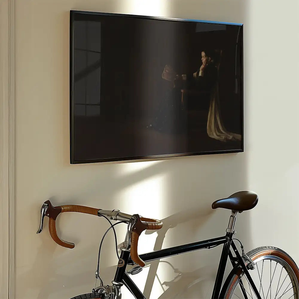 A framed painting of a woman sitting thoughtfully in a dimly lit room, hanging on a wall next to a vintage bicycle.