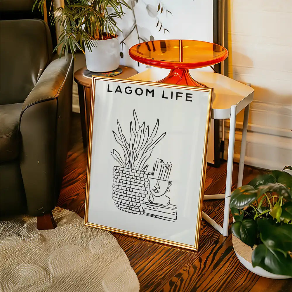 Modern minimalist poster featuring a stylish plant, a decorative pot, and artistic line drawings with the text "LAGOM LIFE" in a chic interior setting.