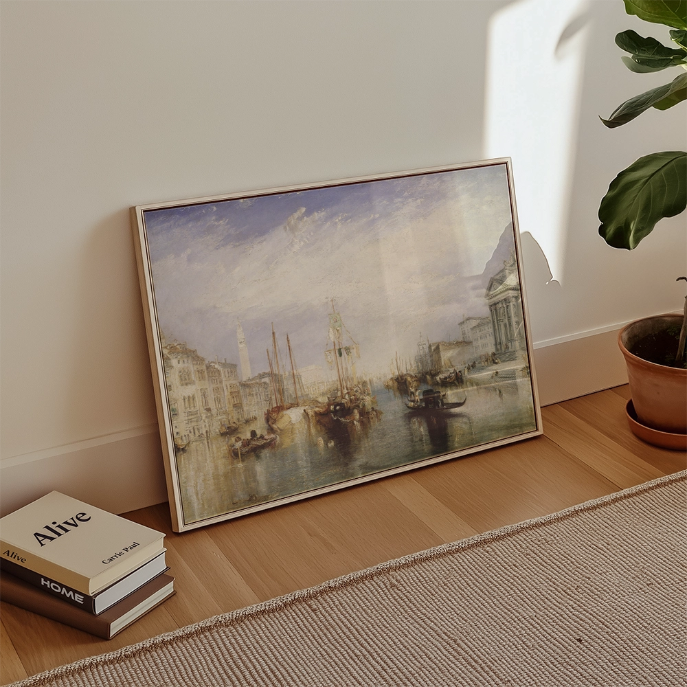Framed painting of a serene seascape with boats, leaning against a wall next to stacked books and a potted plant.