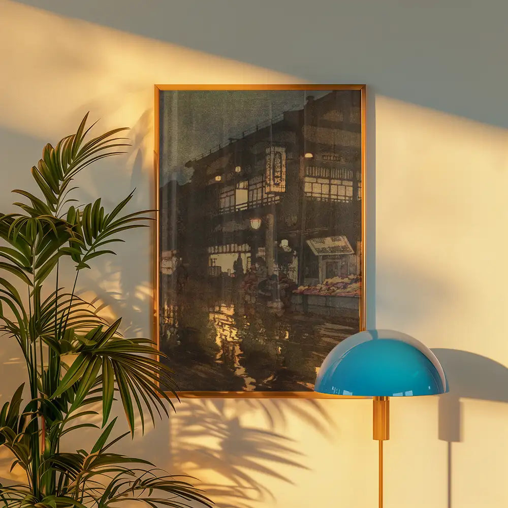 A framed painting of a bustling street scene reflecting in water, accented by warm lighting and surrounded by greenery and a modern lamp.