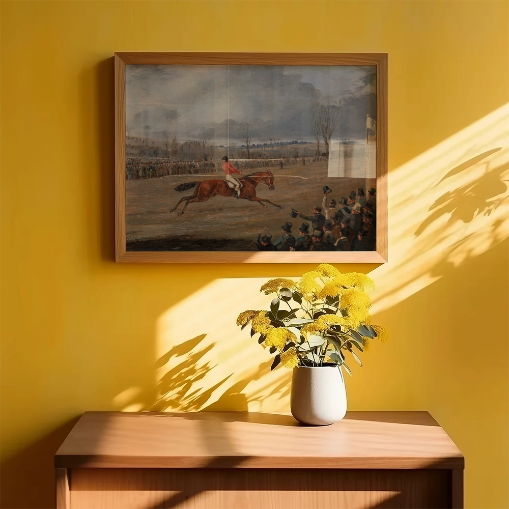 Painting of a horse race in a wooden frame, displayed against a yellow wall, with sunlight casting shadows and a vase of yellow flowers on a wooden table.