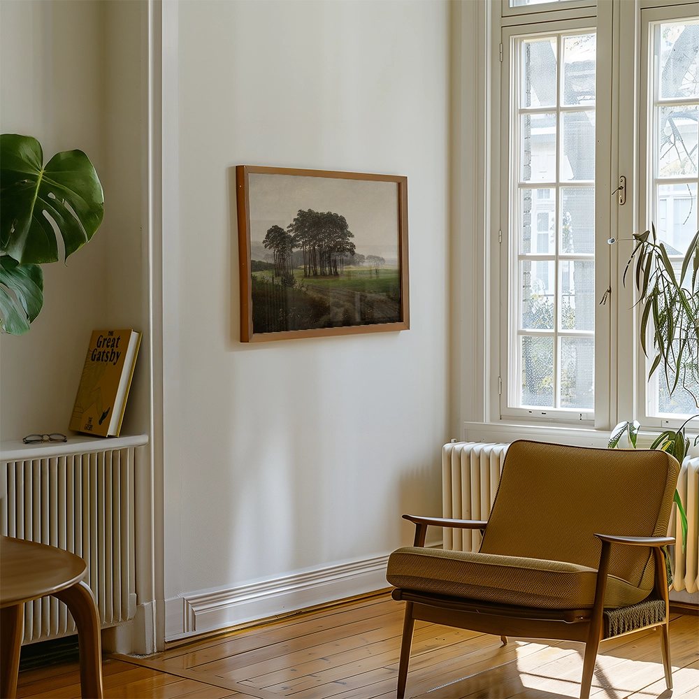 A framed painting of a landscape featuring trees hangs on a light-colored wall in a cozy living room with a yellow armchair, a green plant, and a book on a shelf.