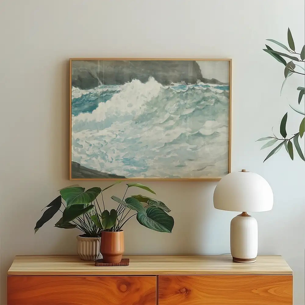 Painting of crashing ocean waves framed and displayed above a wooden console table with potted plants and a lamp.