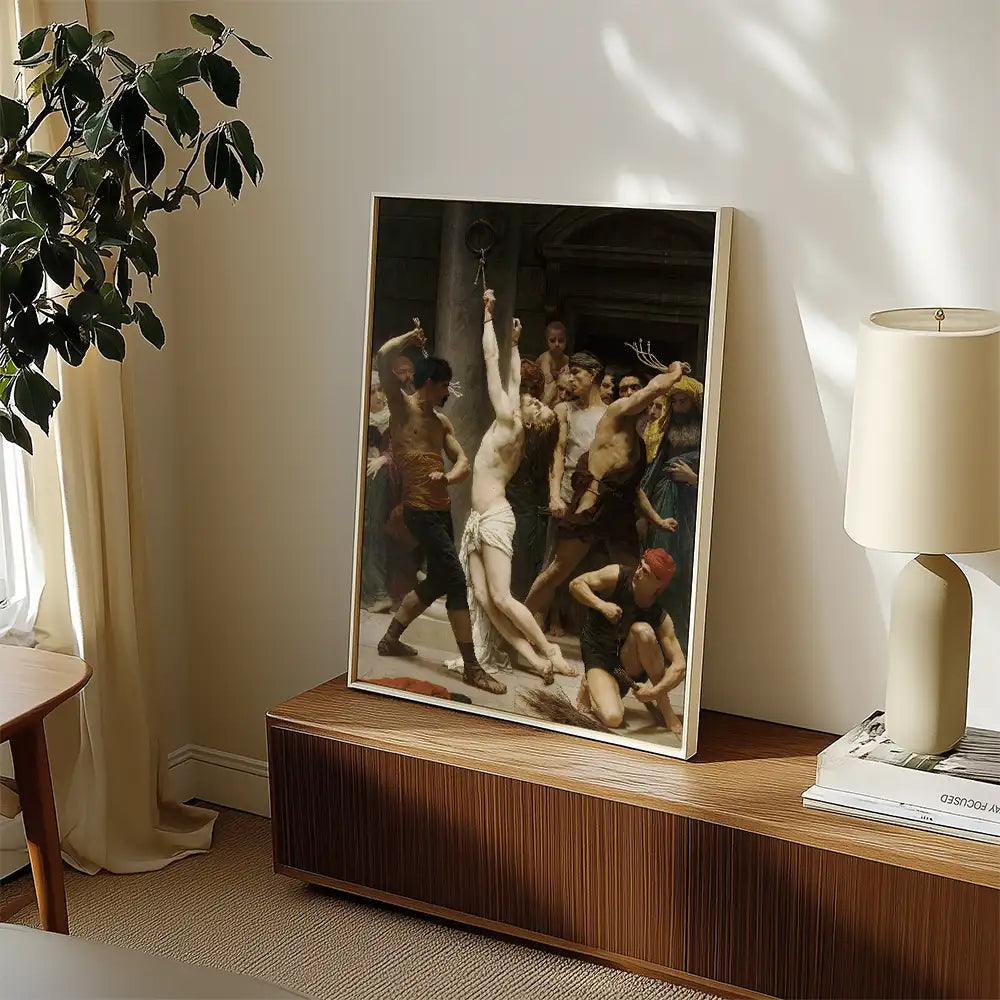 Framed painting depicting a historical scene with a central figure being restrained, surrounded by a crowd of onlookers, displayed on a wooden cabinet beside a lamp and a plant.