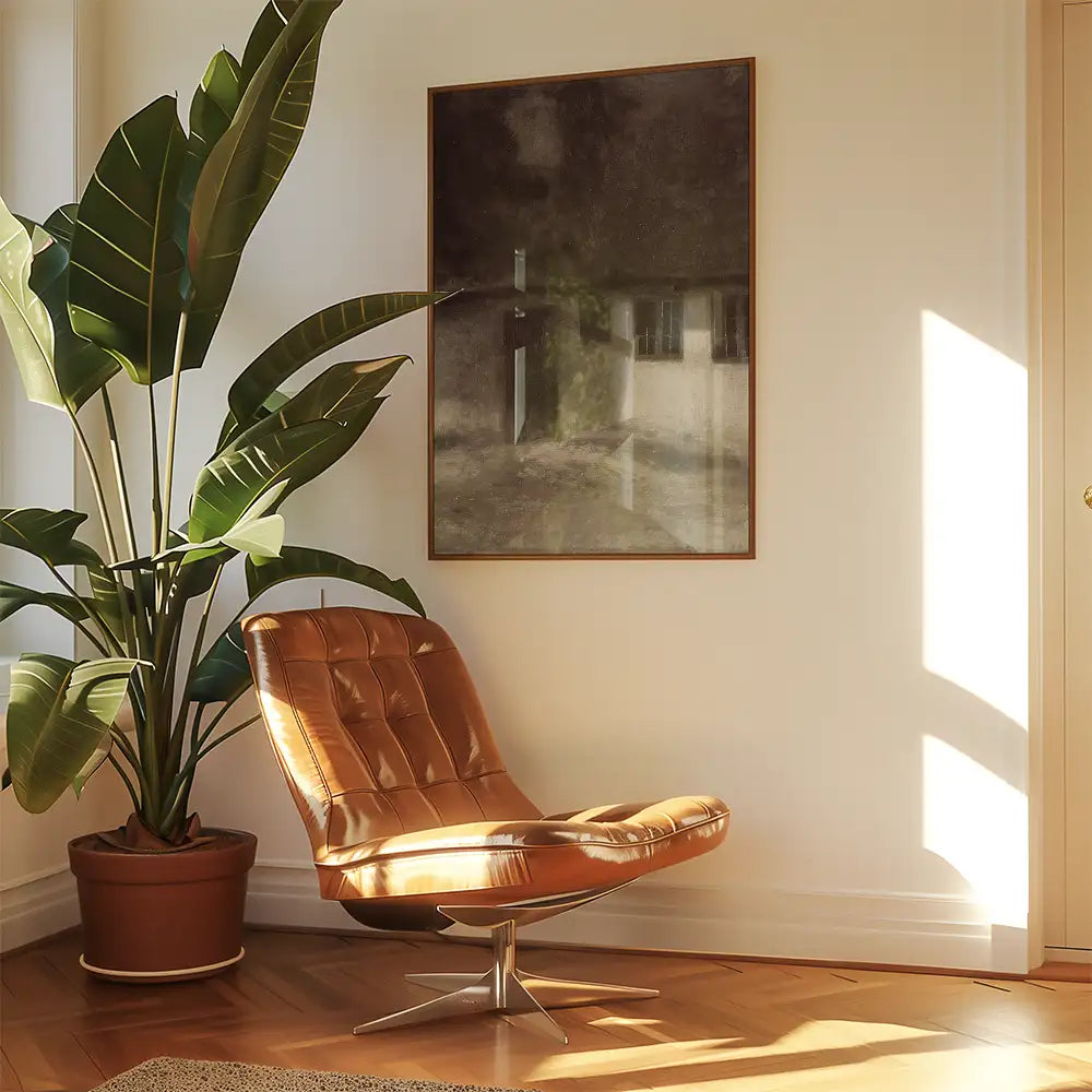 Modern interior featuring a brown leather lounge chair, a large framed painting, and a potted plant beside a sunlit wall.