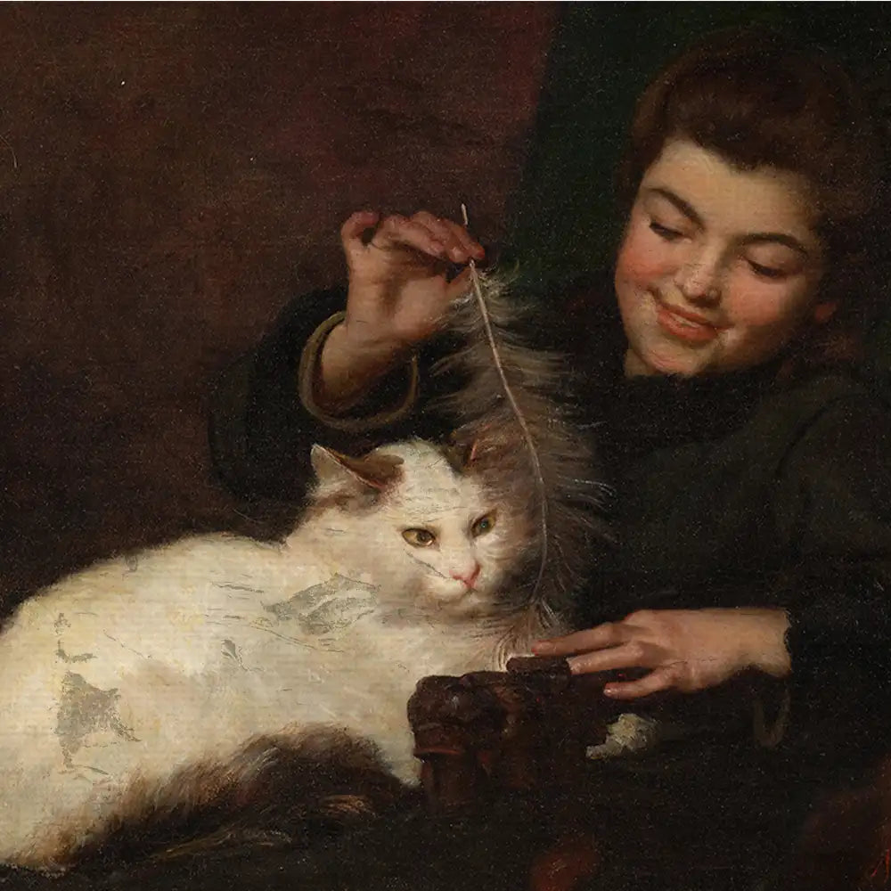 A young girl playing with a feather while sitting next to a white cat in a dimly lit room.
