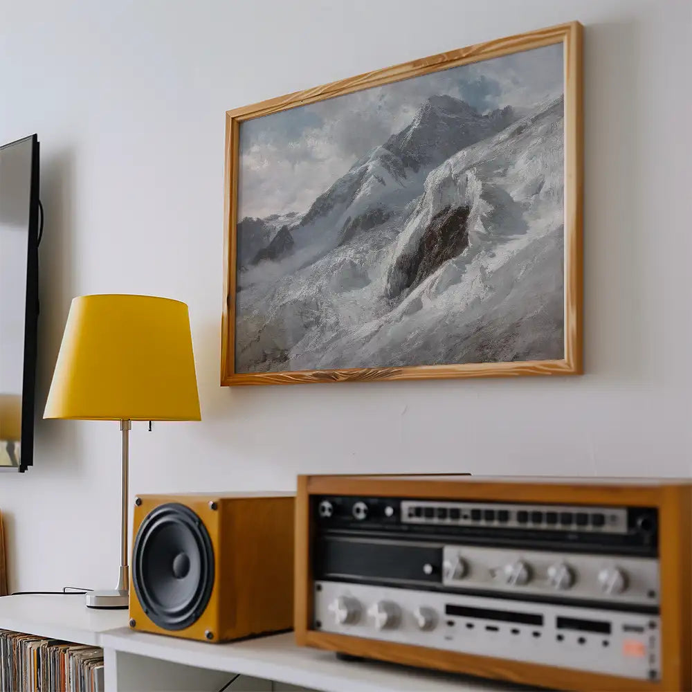 Painting of snowy mountains in a wooden frame hanging on a white wall, with a yellow lamp and vintage audio equipment in the foreground.