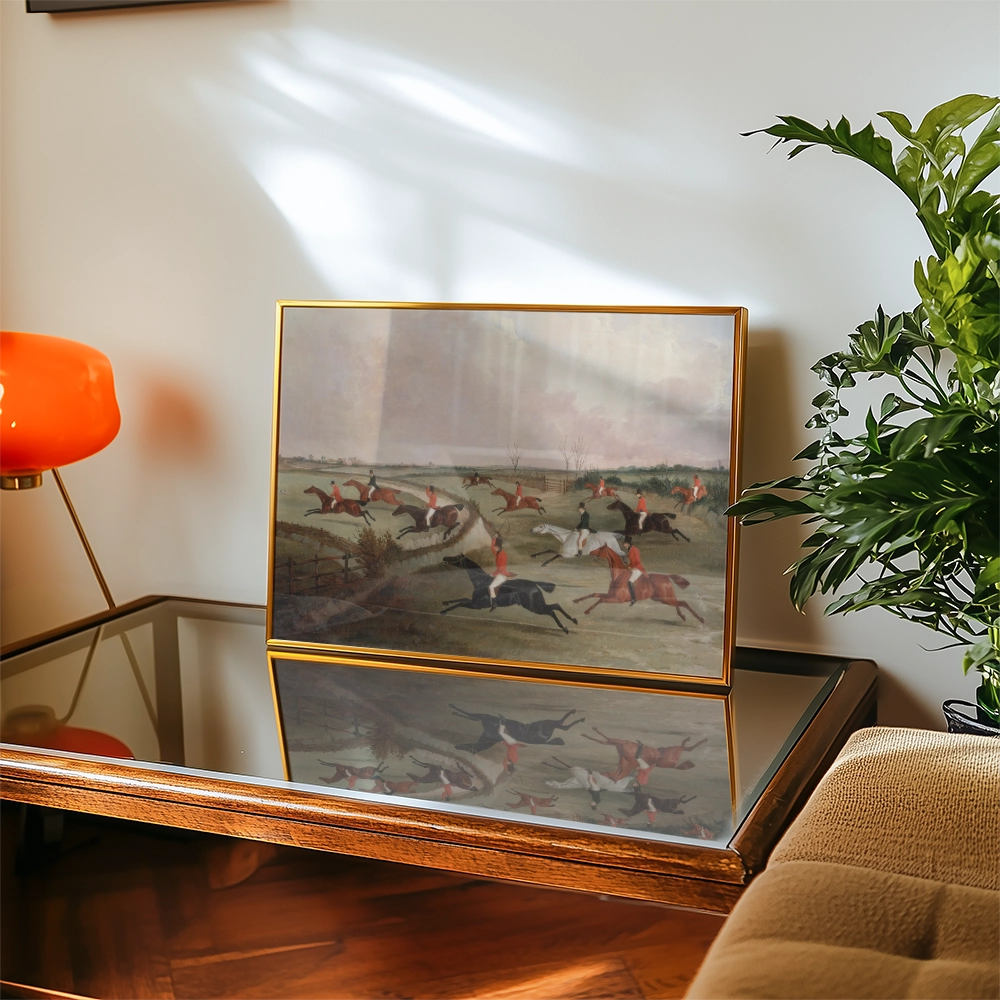 Painting depicting a horse race scene, displayed on a glass-top coffee table with a lamp and plant in the background.