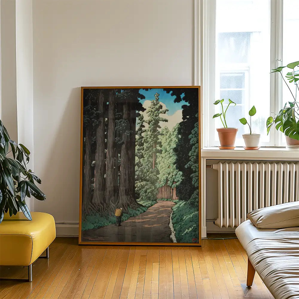 A framed painting depicting a serene tree-lined path, showcasing tall trees and a figure walking, displayed in a stylish living room setting.