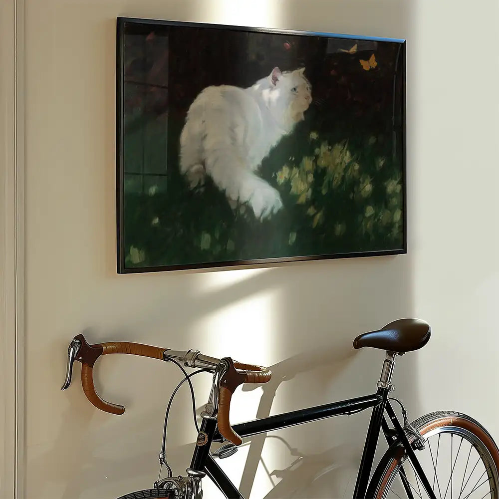 Painting of a white cat in a garden with yellow flowers, framed and hung on a wall above a vintage bicycle.