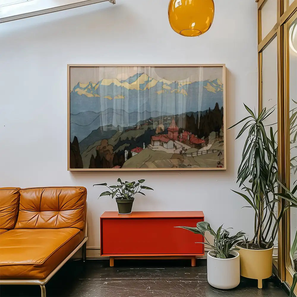 Landscape painting framed and displayed in a modern living room with a brown leather couch, red storage unit, and potted plants.