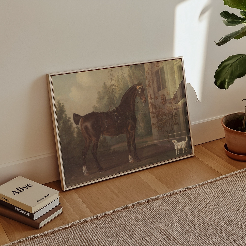 Framed painting of a brown horse in a landscape setting, leaning against a wall with a potted plant and books nearby.