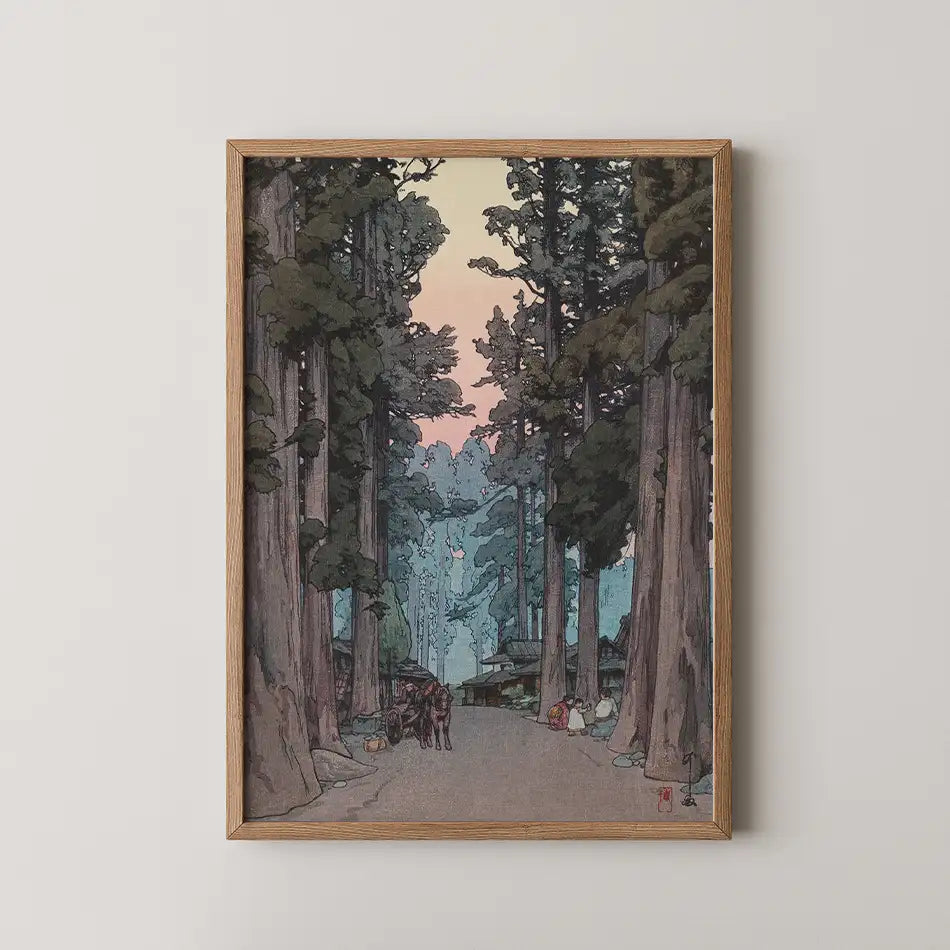 Framed painting of a serene forest path with towering trees and a colorful sunset in the background.