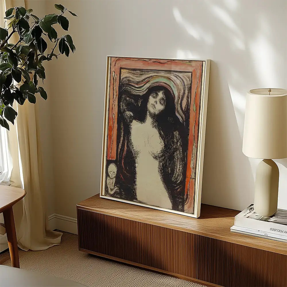 Framed art print of a female figure with flowing dark hair, displayed on a wooden shelf next to a lamp and a plant.