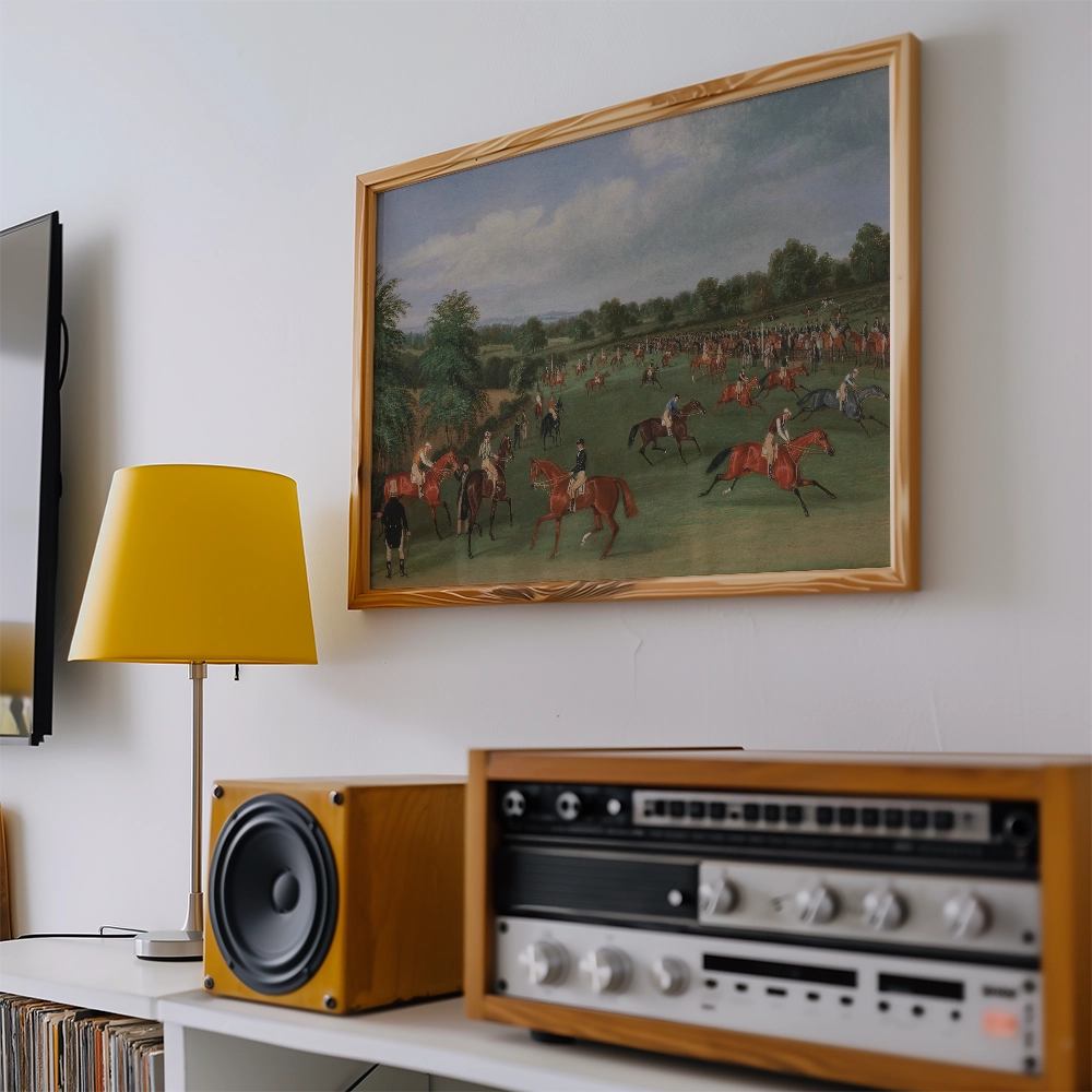 Framed painting of a historical horse riding scene displayed on a wall, alongside a yellow lamp and a vintage audio system.