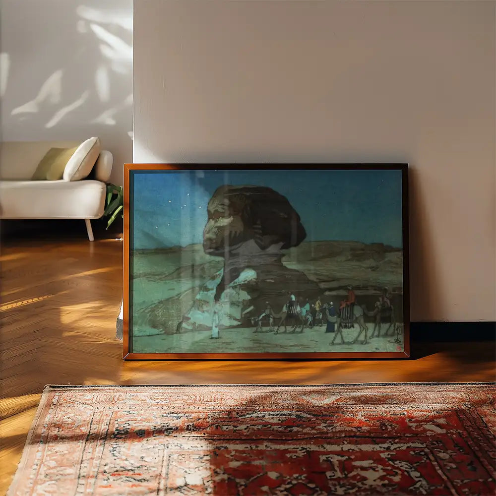 Framed painting of the Great Sphinx of Giza with travelers and camels in a desert landscape, placed on a wooden floor beside a rug and sunlight casting shadows.