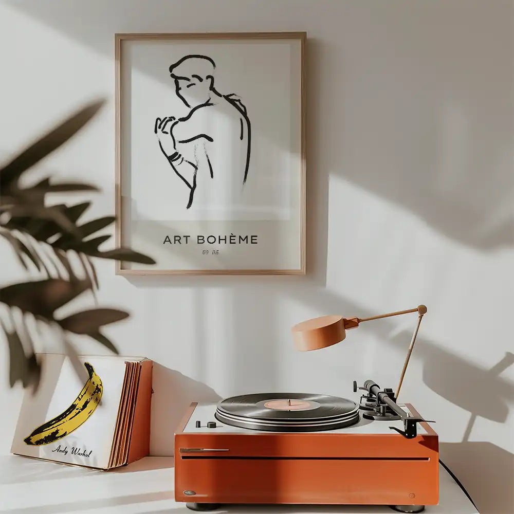Modern minimalistic poster featuring a line drawing of a man, framed and displayed above a vintage record player in a stylish interior setting.