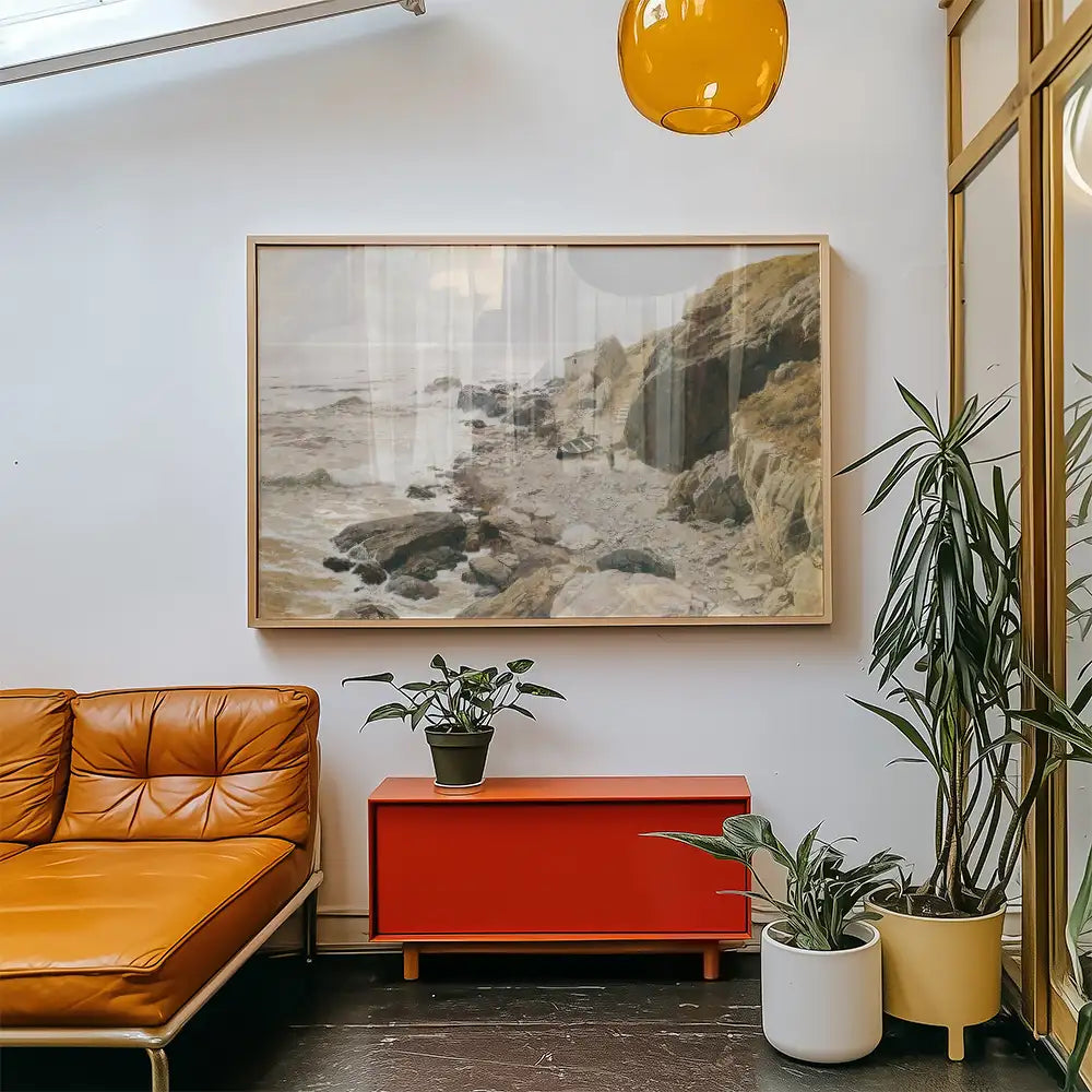A coastal landscape painting hanging on a white wall above a red cabinet, with a brown leather sofa and green potted plants in the foreground.
