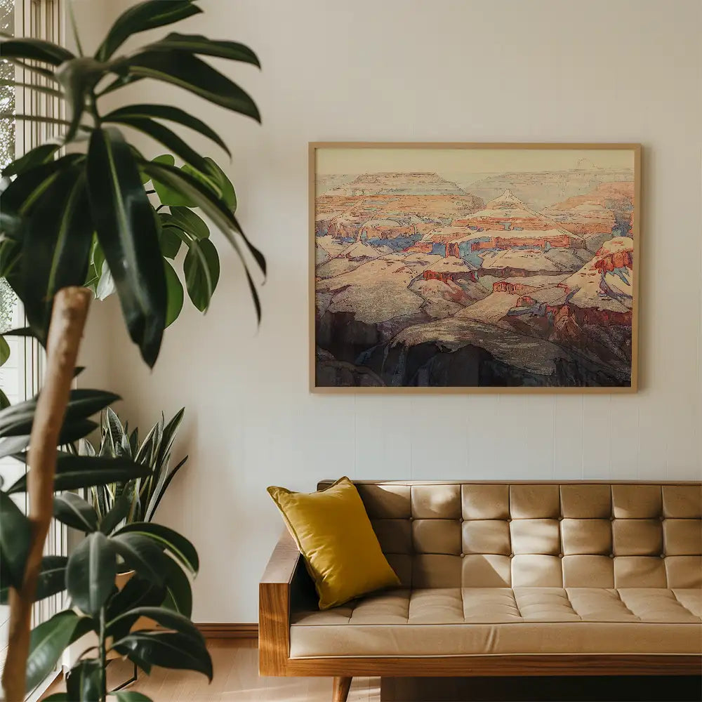 Framed landscape painting of a mountainous terrain displayed on a white wall above a mid-century modern sofa with a yellow pillow, surrounded by indoor greenery.