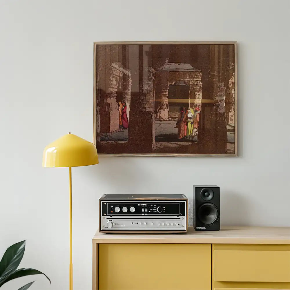Framed painting of a historic scene featuring people in colorful attire, displayed above a yellow lamp and vintage audio equipment on a wooden cabinet.