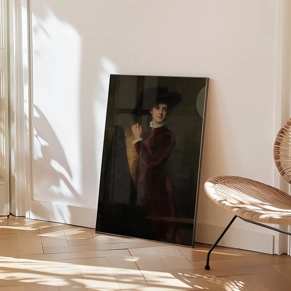 Painting of a woman in a red dress and black hat, leaning against a wall, displayed in a bright room with wooden flooring and a woven chair.