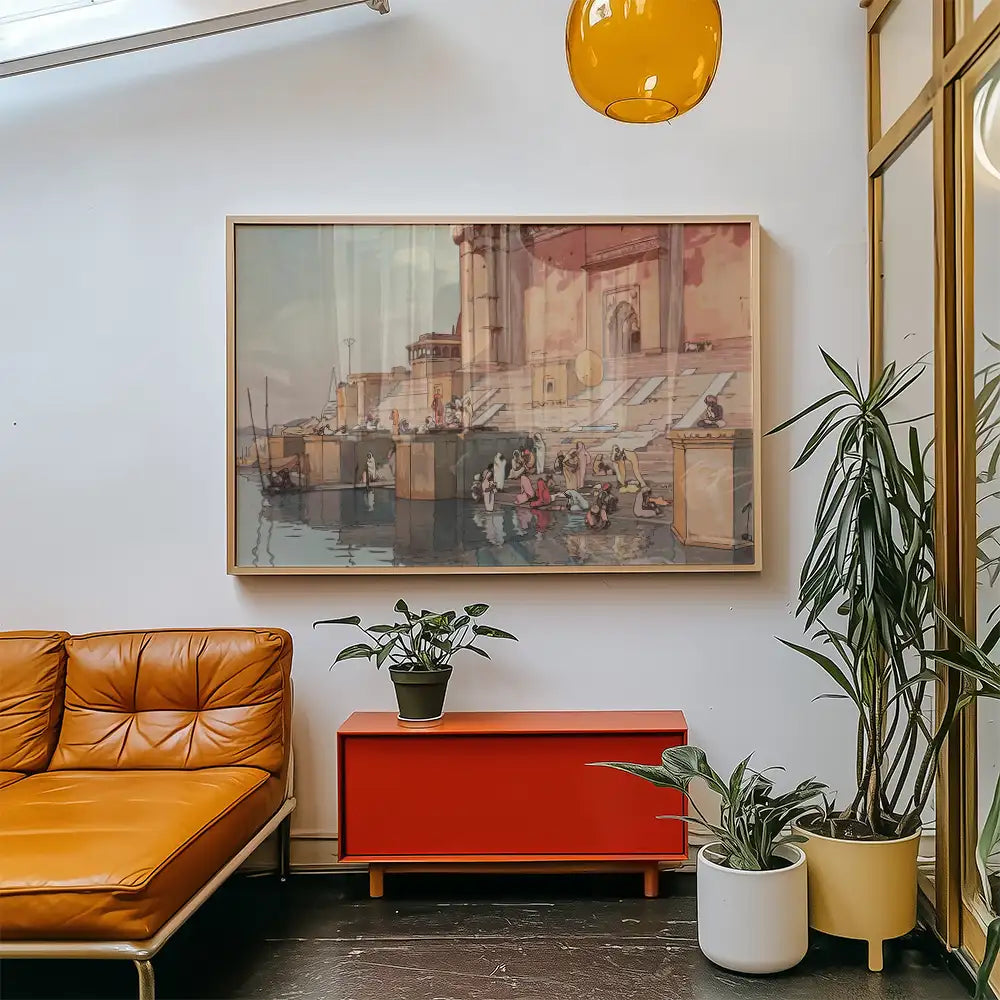 Framed painting of a serene waterfront scene with people, displayed in a modern living room setting with orange leather sofa and potted plants.