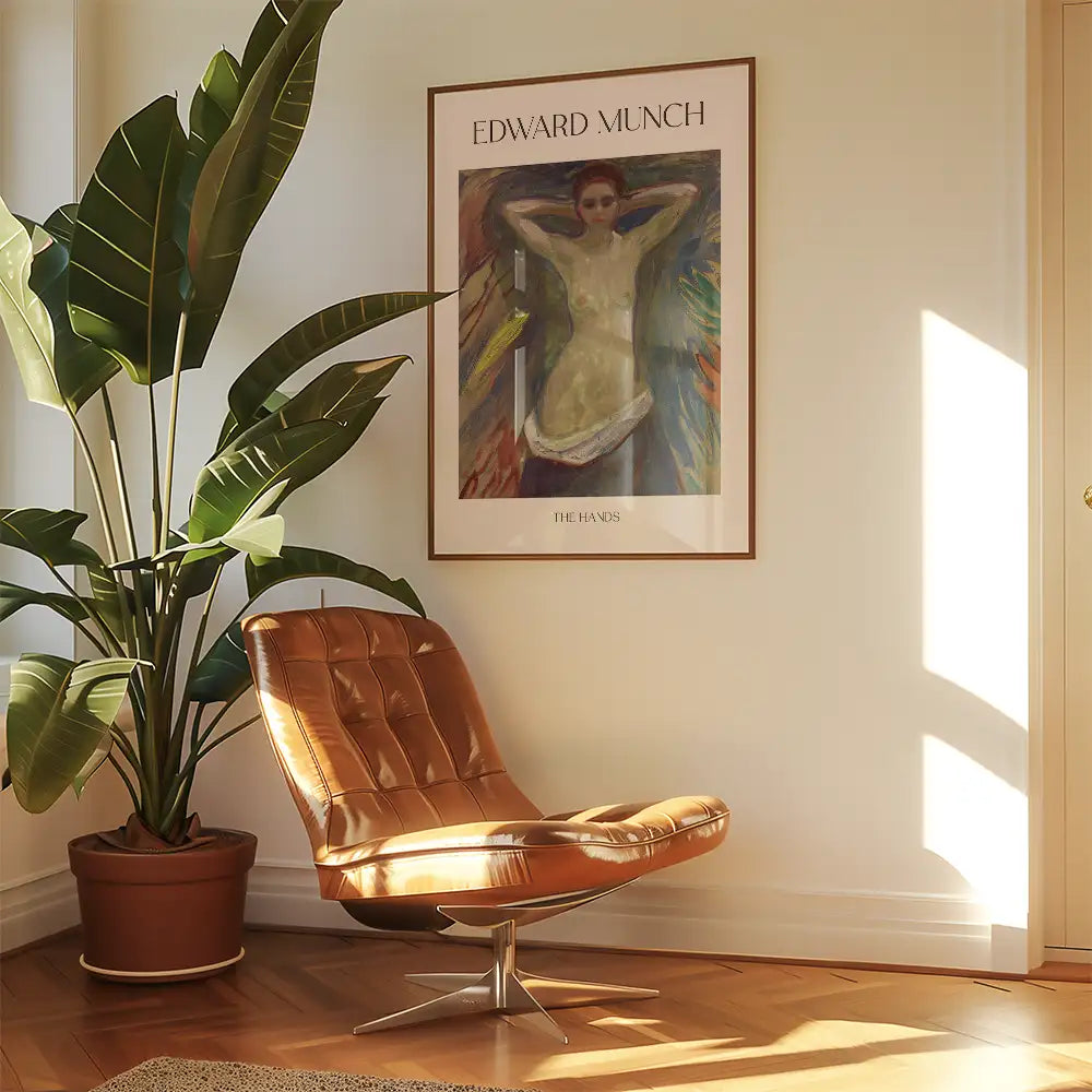 Framed painting by Edward Munch titled "The Hands" displayed above a modern brown lounge chair next to a green plant in a bright room.