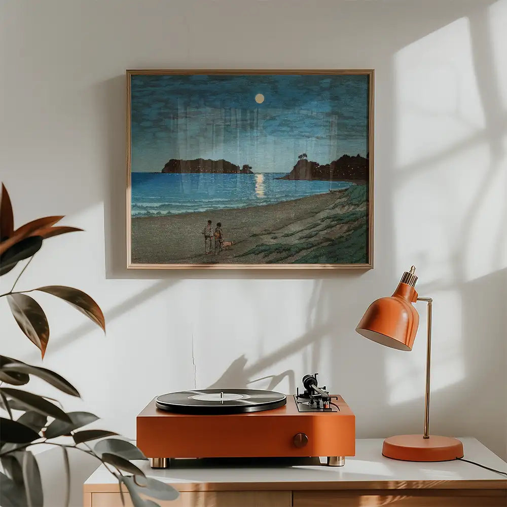 Painting of a serene beach scene with two individuals sitting on the shore, framed above a stylish orange turntable and lamp in a cozy living space.