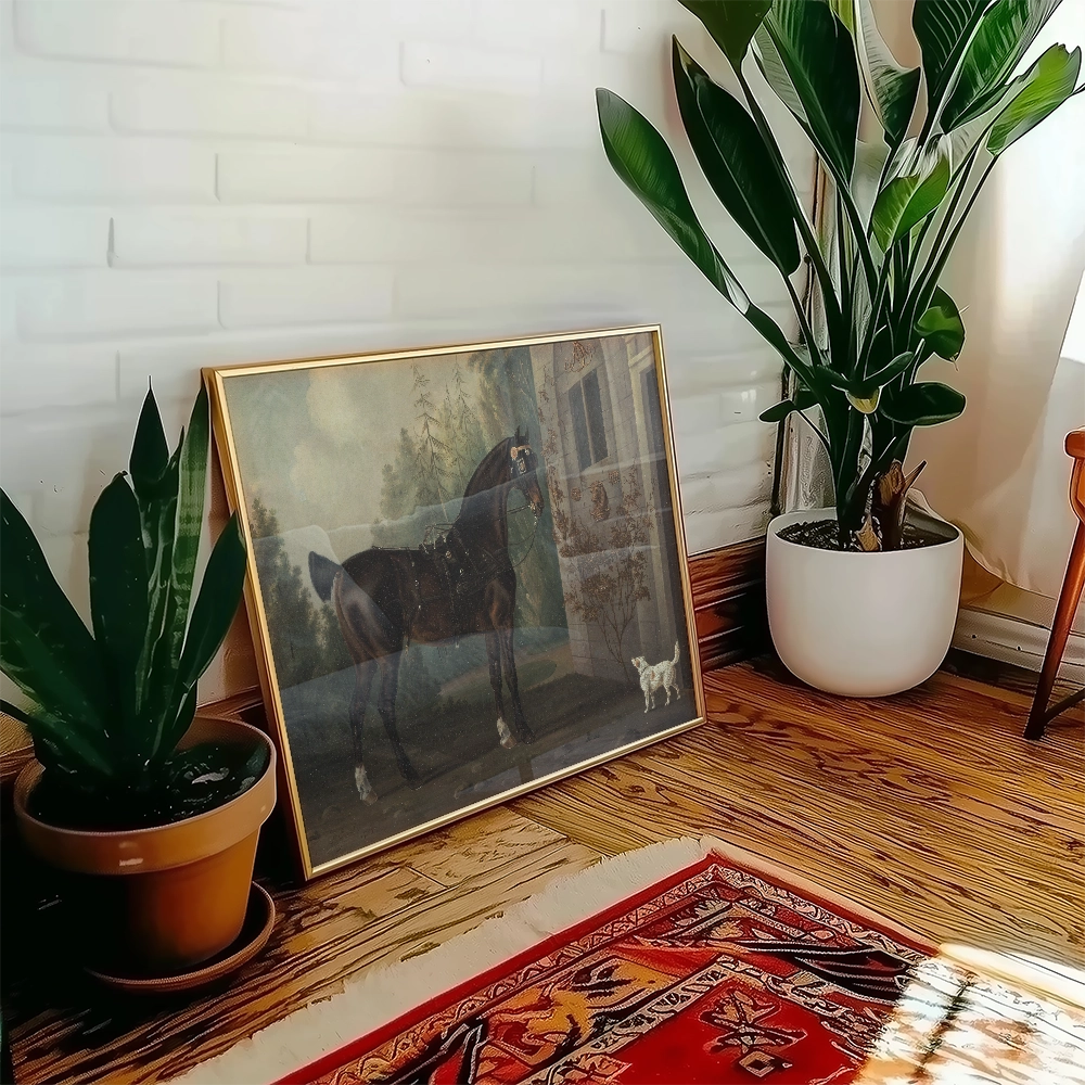 Framed painting of a horse in a natural setting displayed on a wooden floor beside a potted plant and a decorative rug.
