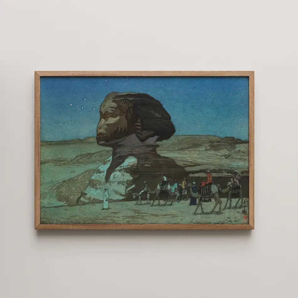 Painting of the Great Sphinx of Giza with camels and figures traveling in the foreground, set against a starry sky, framed in wood.