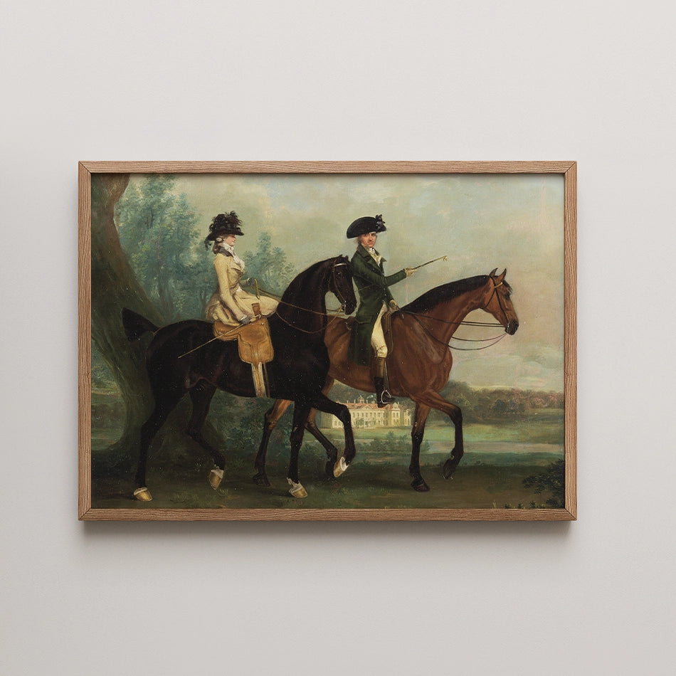Painting of two horse riders, one wearing a cream outfit and the other in a dark green coat, framed in wood, with a landscape background featuring a house and trees.