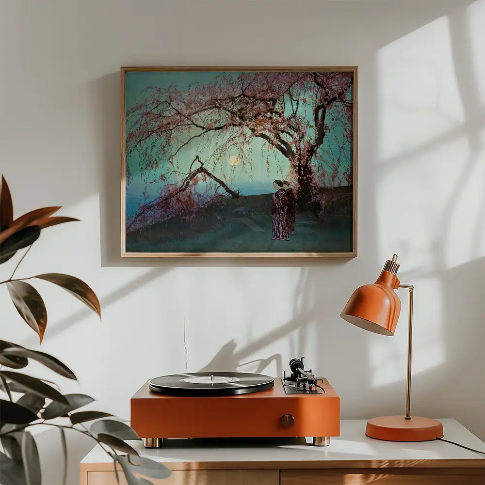 Painting of a woman standing under a blooming tree with pink flowers, framed and displayed on a wall above a turntable and an orange desk lamp.