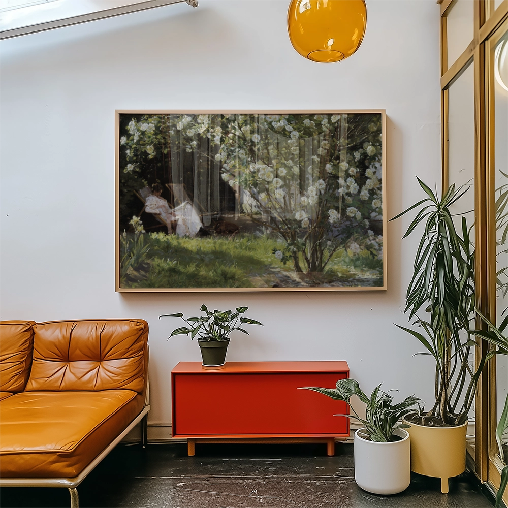 A serene painting of a woman relaxing in a blossoming garden, framed and displayed above a vibrant orange couch, accompanied by houseplants and a red cabinet in a modern living space.