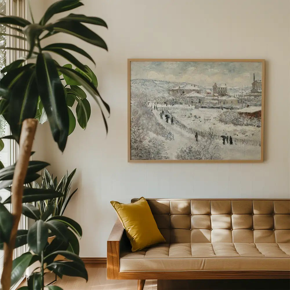 Painting of a rural winter landscape featuring people walking along a snowy path, framed and hung above a modern tan sofa with a yellow cushion, complemented by green indoor plants.