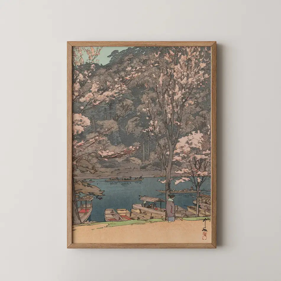 Framed painting of a serene landscape depicting cherry blossom trees by a river with boats, showcasing soft pastel colors.